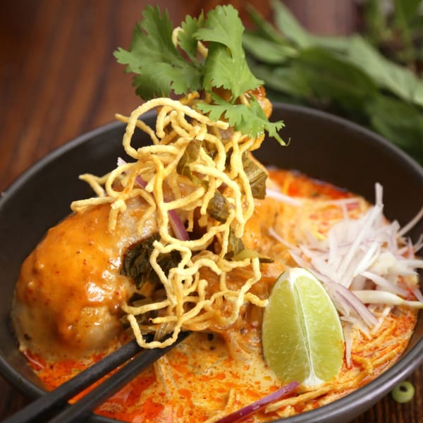 Laem Buri's Khao Soi with chicken, crispy noodles, cilantro, and a lime wedge.